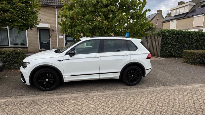 Witte lesauto van Rijles32 met een L-bord op het dak, geparkeerd in een woonstraat