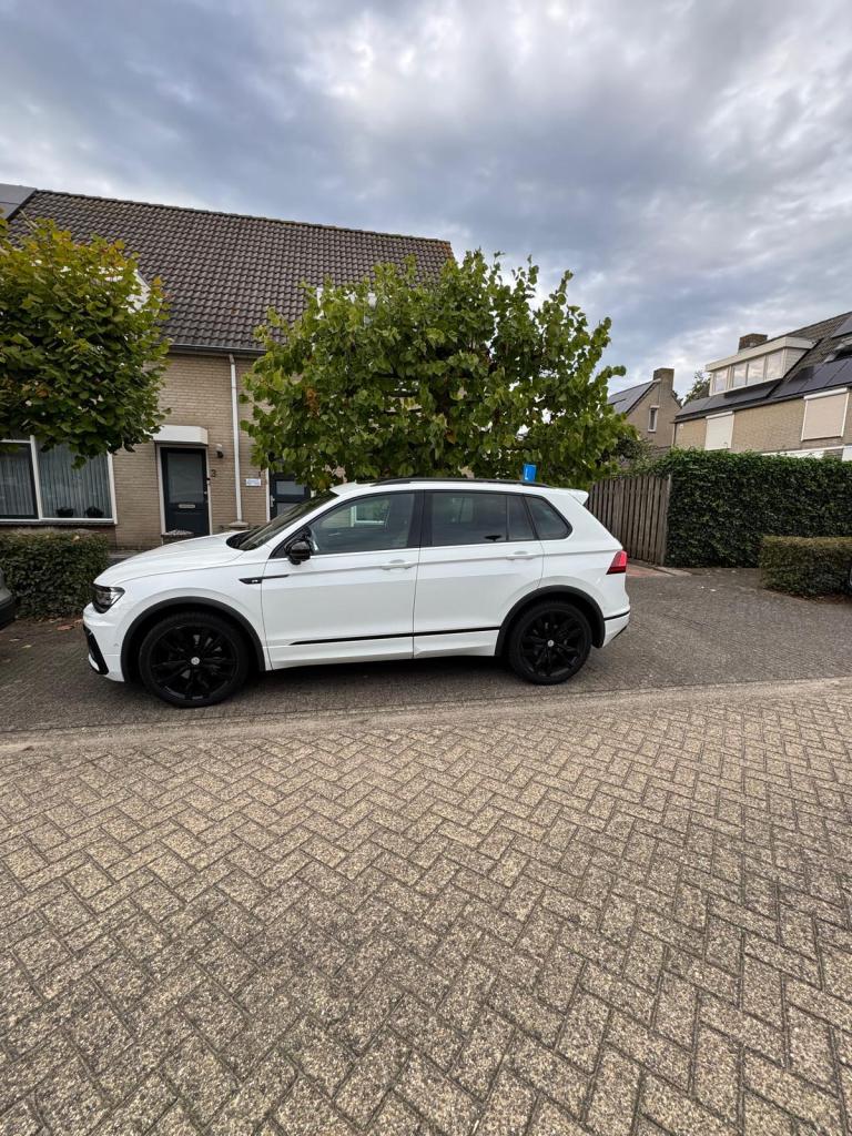 Witte lesauto van Rijles32 met een L-bord op het dak, geparkeerd in een woonstraat